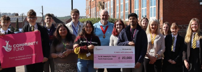 Students and staff stood outside QE School holding a large cheque for £20,000 National Lottery Grant